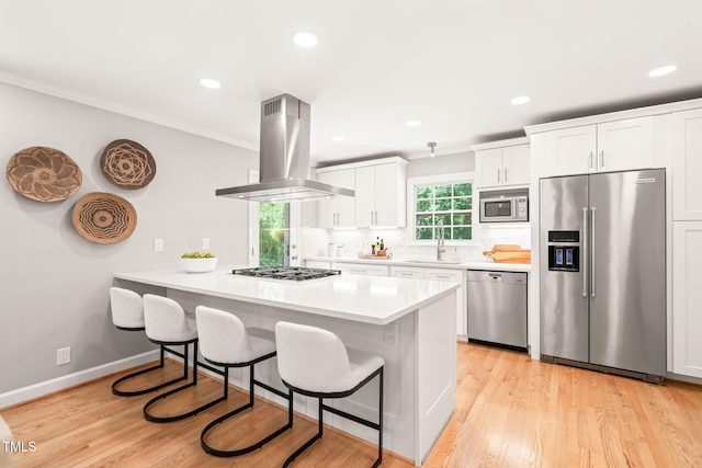 3420 Sheridan Dr, Durham, NC 27707 - kitchen featuring stainless steel appliances, island exhaust hood, a kitchen bar, a peninsula, and recessed lighting