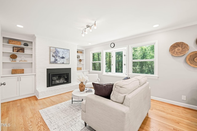 3420 Sheridan Dr, Durham, NC 27707 - living room featuring baseboards, light wood finished floors, a fireplace, ornamental molding, and built in features