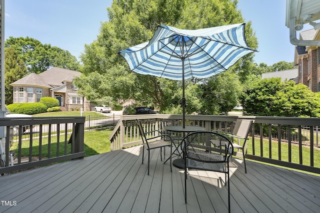 deck with fence, outdoor dining area, and a yard