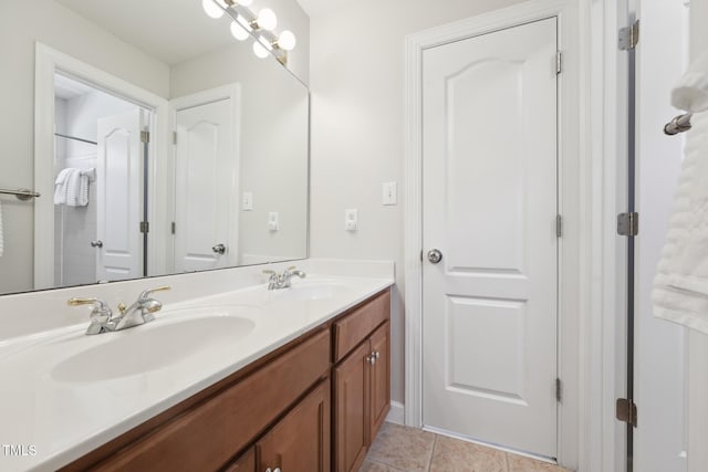 full bath featuring double vanity, a sink, and tile patterned flooring