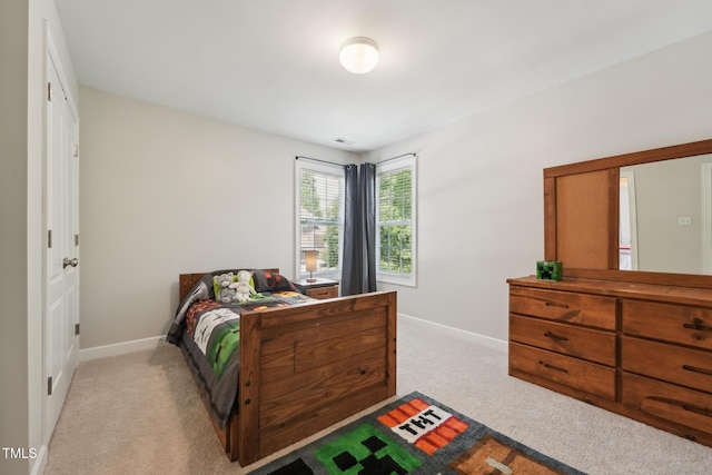 bedroom featuring baseboards, light colored carpet, and visible vents