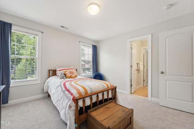 bedroom featuring baseboards, visible vents, and light colored carpet