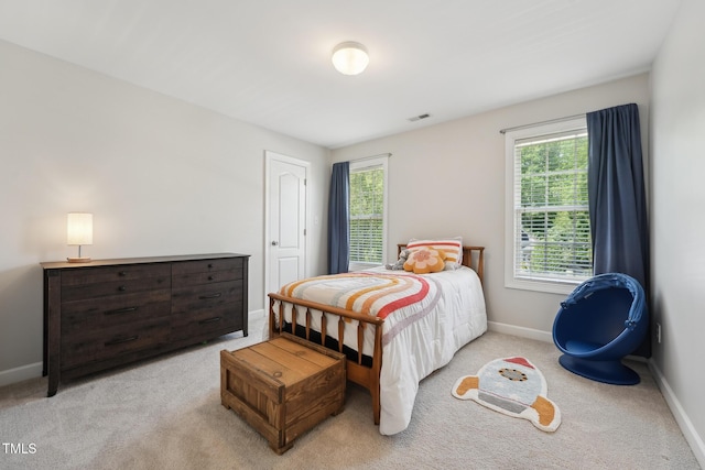 bedroom featuring visible vents, baseboards, and multiple windows