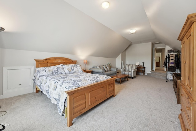 bedroom with light colored carpet and lofted ceiling