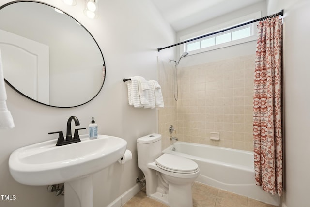 bathroom with toilet, baseboards, tile patterned floors, a sink, and shower / tub combo