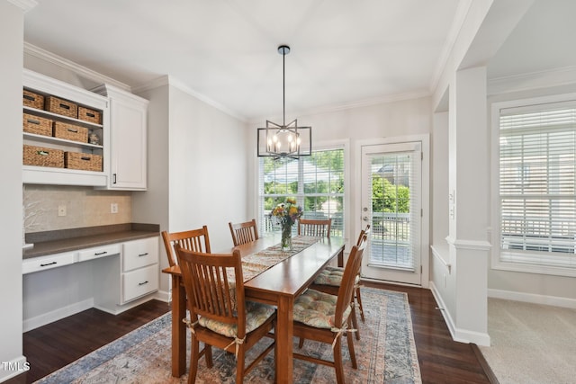 dining room with ornamental molding, dark wood finished floors, built in desk, and a chandelier
