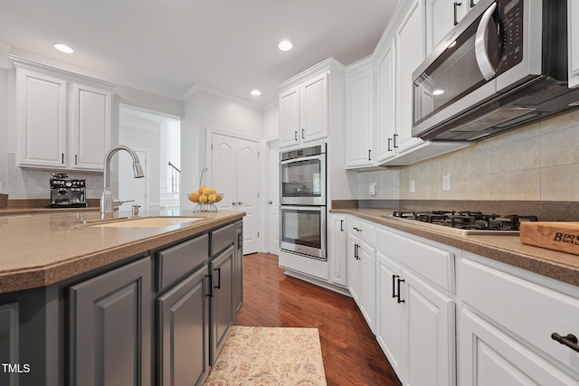 kitchen with a sink, gray cabinets, appliances with stainless steel finishes, and white cabinets