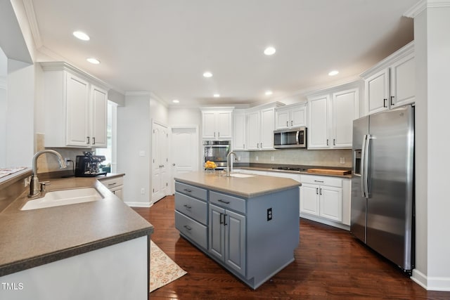 kitchen featuring white cabinets, stainless steel appliances, gray cabinetry, and a sink