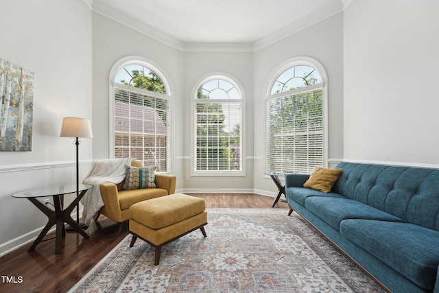 living area with baseboards, ornamental molding, and wood finished floors
