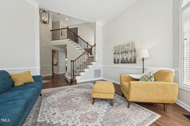 living room featuring stairway, a wealth of natural light, wood finished floors, and visible vents
