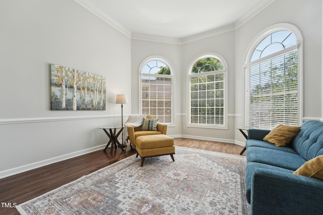 living area with baseboards, ornamental molding, and wood finished floors