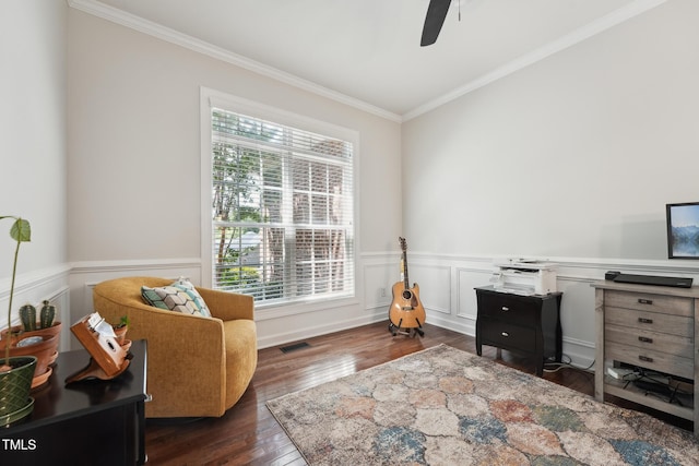 living area featuring crown molding, dark wood-style flooring, ceiling fan, a wainscoted wall, and visible vents
