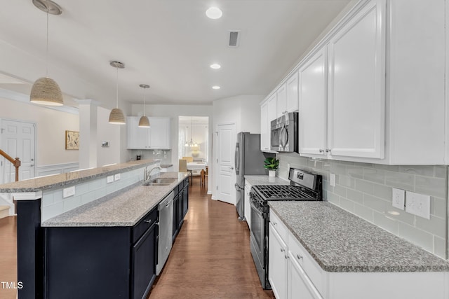 3801 Althorp Dr, Raleigh, NC 27616 - kitchen featuring white cabinetry, tasteful backsplash, a sink, dark wood finished floors, and stainless steel appliances