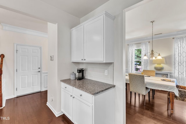 3801 Althorp Dr, Raleigh, NC 27616 - kitchen with decorative backsplash, dark wood-style flooring, baseboards, white cabinets, and dark stone counters
