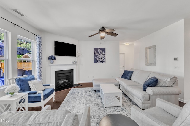 3801 Althorp Dr, Raleigh, NC 27616 - living area featuring a ceiling fan, visible vents, a fireplace with flush hearth, wood finished floors, and baseboards