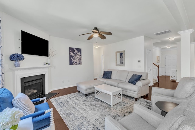 3801 Althorp Dr, Raleigh, NC 27616 - living area featuring a glass covered fireplace, stairs, a ceiling fan, wood finished floors, and visible vents