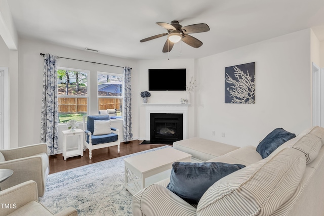 3801 Althorp Dr, Raleigh, NC 27616 - living area featuring a fireplace with flush hearth, ceiling fan, wood finished floors, and visible vents