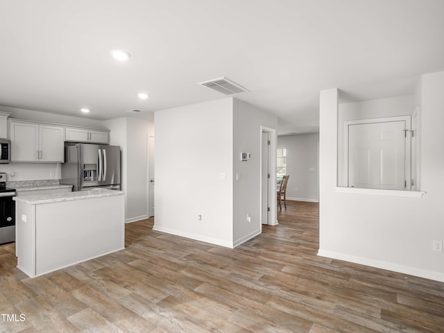 6858 Keeneland Dr, Whitsett, NC 27377 - kitchen featuring stainless steel appliances, recessed lighting, visible vents, and light wood-type flooring
