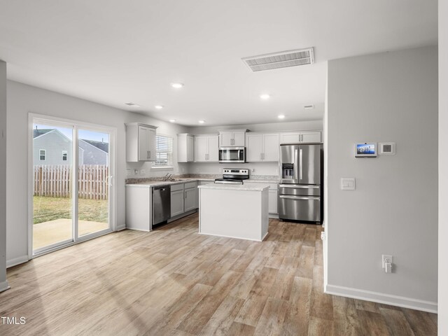 6858 Keeneland Dr, Whitsett, NC 27377 - kitchen with visible vents, recessed lighting, light countertops, light wood finished floors, and appliances with stainless steel finishes