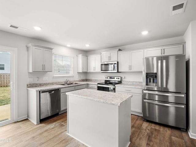 6858 Keeneland Dr, Whitsett, NC 27377 - kitchen featuring light countertops, appliances with stainless steel finishes, a sink, and visible vents