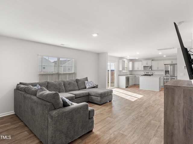6858 Keeneland Dr, Whitsett, NC 27377 - living area with light wood-type flooring, recessed lighting, baseboards, and visible vents