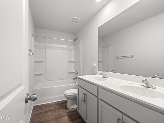 6858 Keeneland Dr, Whitsett, NC 27377 - bathroom with double vanity, toilet, a sink, and wood finished floors