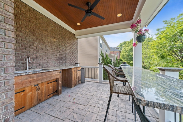 view of patio / terrace with an outdoor kitchen, a sink, a ceiling fan, and outdoor dining area