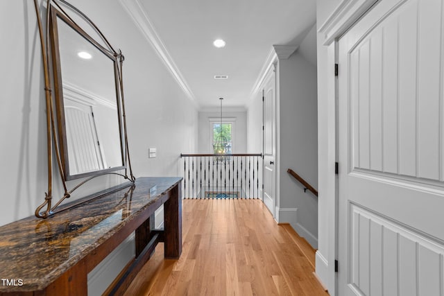 hallway featuring recessed lighting, an upstairs landing, ornamental molding, and light wood-style flooring