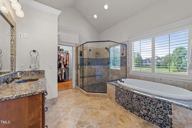 bathroom featuring vanity, lofted ceiling, a spacious closet, a bath, and a stall shower