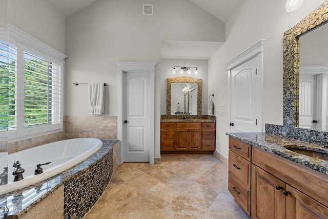 bathroom with a sink, high vaulted ceiling, two vanities, visible vents, and a bath
