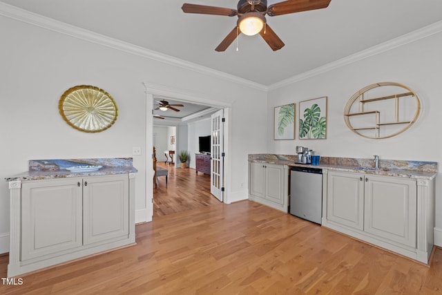 kitchen featuring ornamental molding, light wood-style floors, baseboards, ceiling fan, and white cabinetry