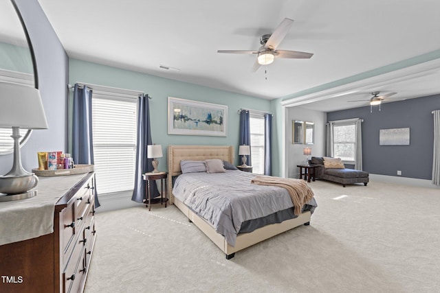 bedroom with baseboards, visible vents, ceiling fan, and light colored carpet