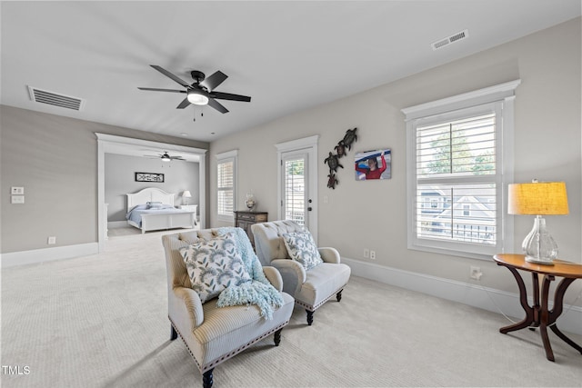 sitting room with visible vents, a ceiling fan, carpet, and baseboards