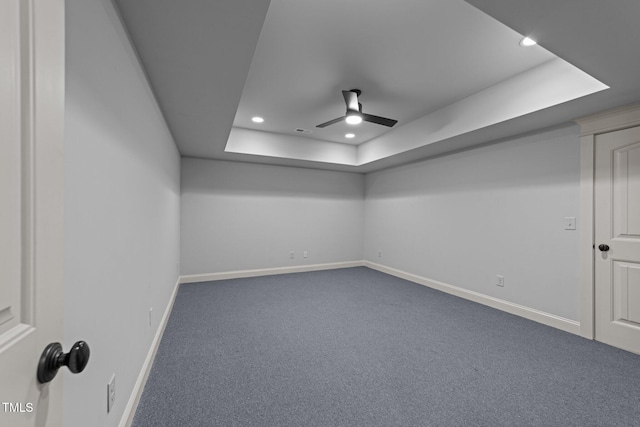 unfurnished room featuring ceiling fan, dark carpet, recessed lighting, baseboards, and a tray ceiling
