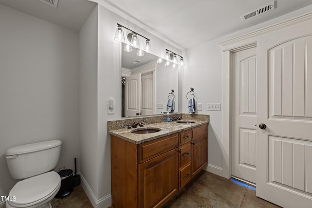 bathroom with a sink, toilet, double vanity, and visible vents