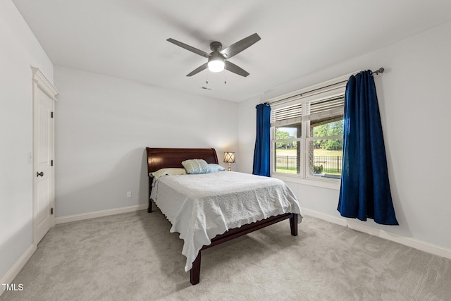 bedroom featuring baseboards, ceiling fan, and carpet