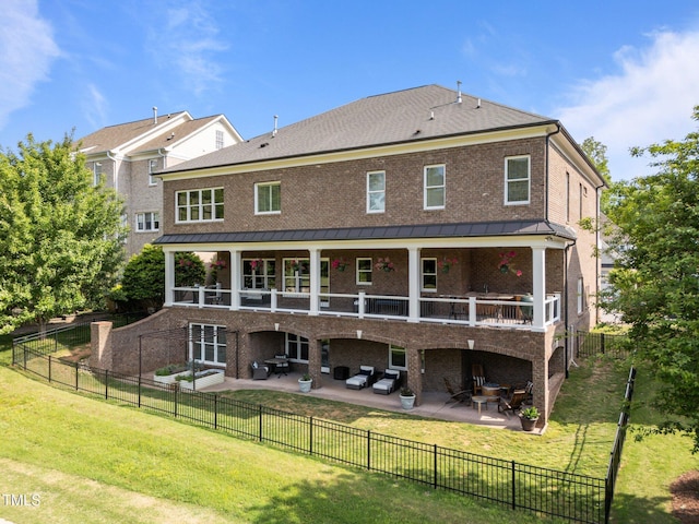rear view of property featuring a patio, brick siding, a lawn, and an outdoor hangout area