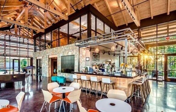 bar featuring high vaulted ceiling, wood ceiling, and beam ceiling