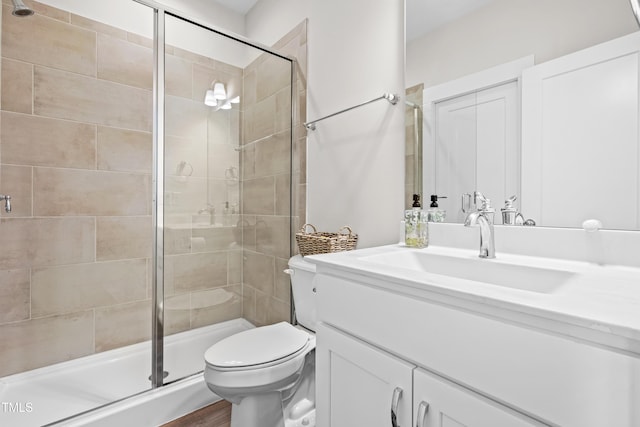 bathroom featuring vanity, a stall shower, and toilet