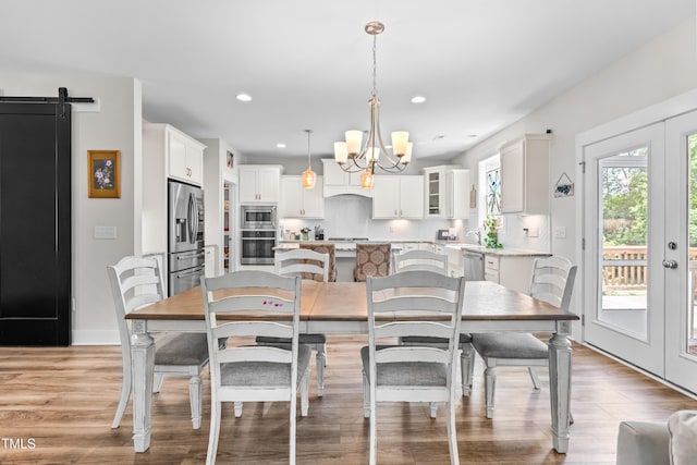 dining room featuring baseboards, recessed lighting, a chandelier, french doors, and light wood finished floors