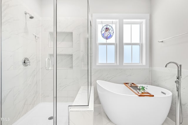 bathroom featuring a freestanding bath, tile walls, and a shower stall