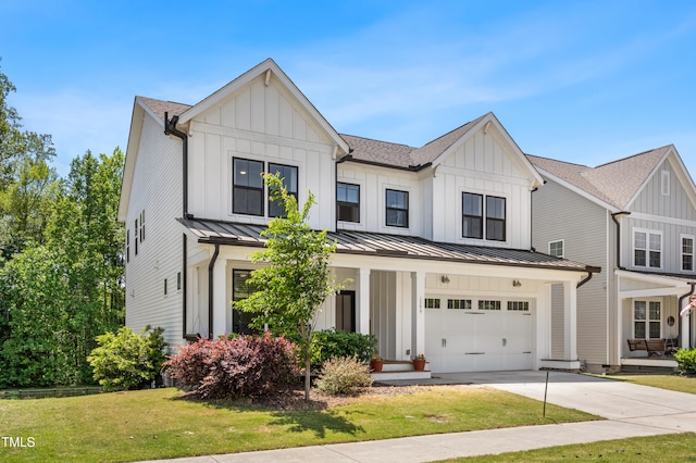 view of front of house featuring board and batten siding, driveway, and a front yard