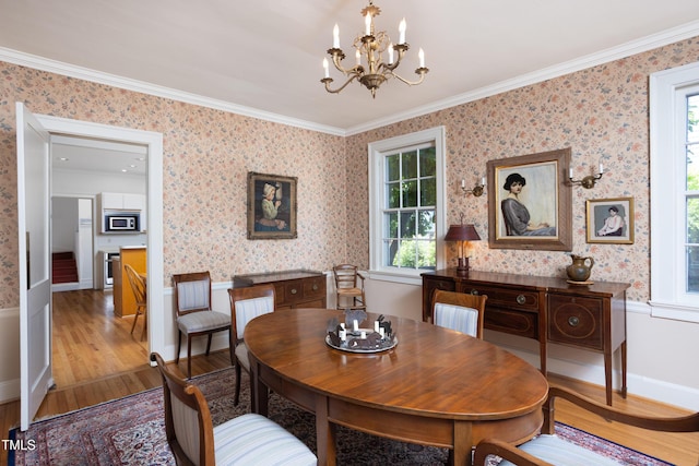 19 Oak Dr, Durham, NC 27707 - dining space featuring crown molding, wallpapered walls, a chandelier, and wood finished floors