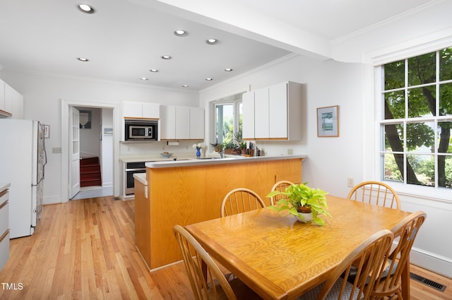 19 Oak Dr, Durham, NC 27707 - kitchen featuring appliances with stainless steel finishes, light countertops, a peninsula, ornamental molding, and white cabinetry