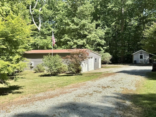 view of home's exterior with a garage, an outbuilding, and a forest view