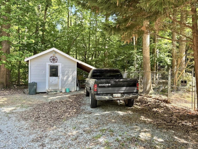 view of outdoor structure with fence and an outbuilding