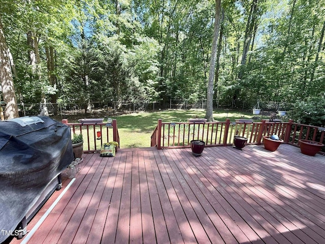deck with a fenced backyard, grilling area, and a yard