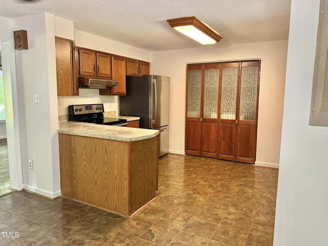 kitchen with brown cabinetry, appliances with stainless steel finishes, light countertops, a peninsula, and under cabinet range hood