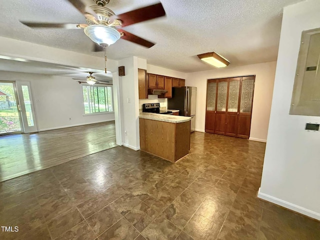 kitchen with a peninsula, open floor plan, a textured ceiling, a ceiling fan, and stainless steel appliances