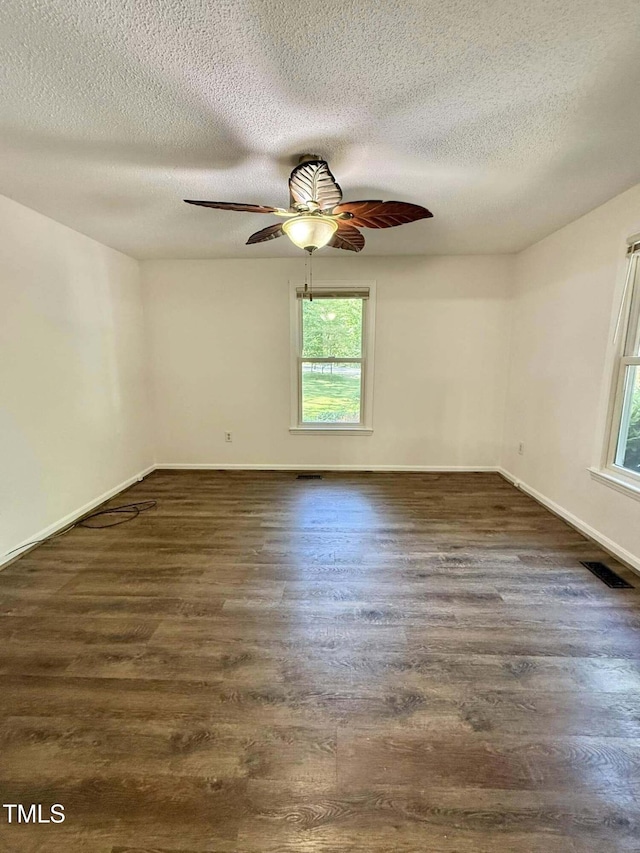 unfurnished room with visible vents, baseboards, a textured ceiling, a ceiling fan, and dark wood finished floors